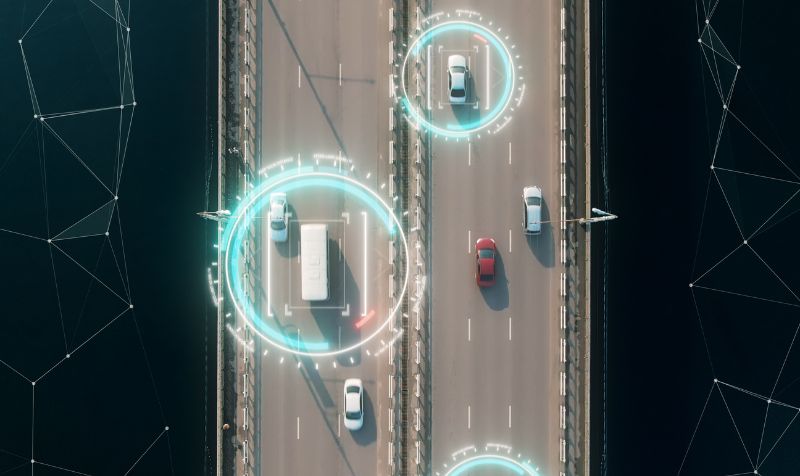 Aerial view of self driving autopilot cars driving on a highway with technology tracking them, showing speed and who is controlling the car. Visual effects clip shot. 